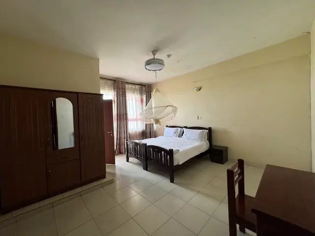 Double room with a wooden wardrobe, double bed and desk