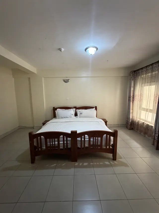 Executive Double Room: double bed below a tall curtained window