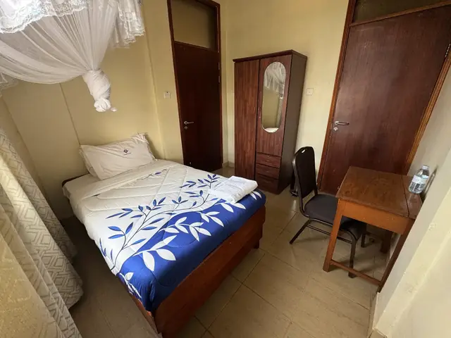 Executive Single Room: single bed with a blue floral duvet, wardrobe, desk and chair