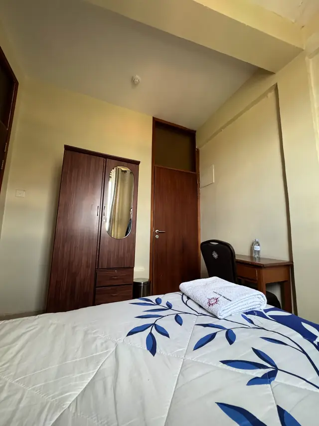 Executive Single Room: wardrobe, desk and folded towels on the bed
